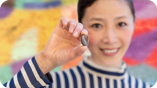 補聴器を手に持つ女性の写真