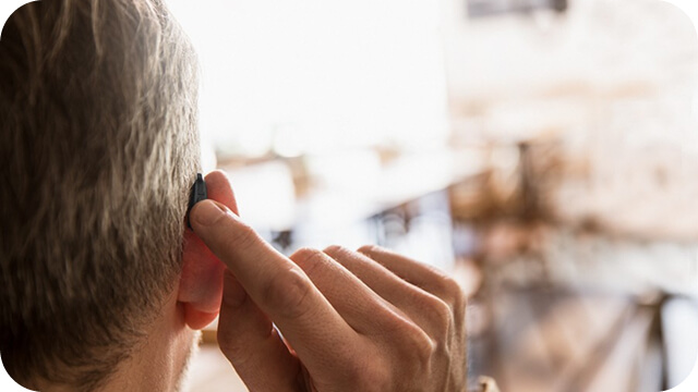 補聴器に手をそえる人の写真